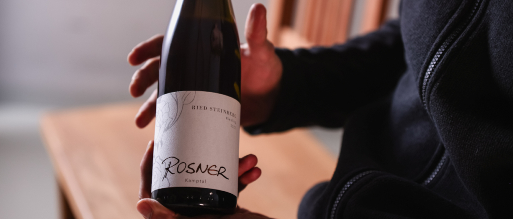 Eine Flasche vom Weingut Rosner gehalten von den Händen Stefans